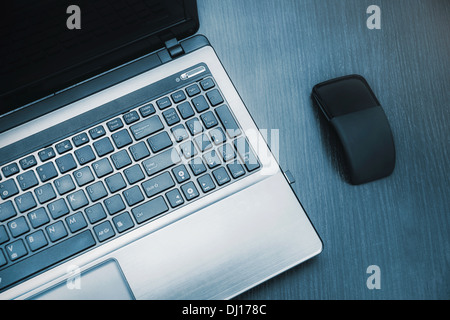 Laptop und moderne flache Maus auf Schreibtisch aus Holz Stockfoto