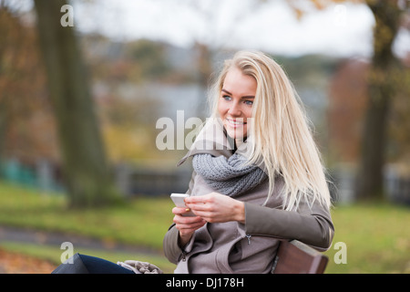 Schöne, glückliche junge Frau mit blonden Haaren entspannend in einem park Stockfoto