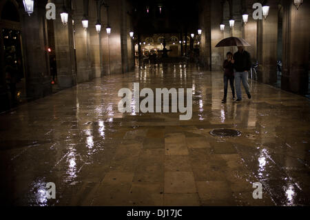 Gotischen Viertel von Barcelona, Spanien-18. November, 2013.A paar Zuflucht unter einem Regenschirm in der Straße von der Rambla zur Plaça Real in Barcelona. Dauerregen über Barcelona nach Monaten ohne Regen. Bildnachweis: Jordi Boixareu/Alamy Live-Nachrichten Stockfoto