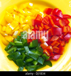 Gelbe, grüne und rote Paprika auf Teller in Scheiben geschnitten Stockfoto