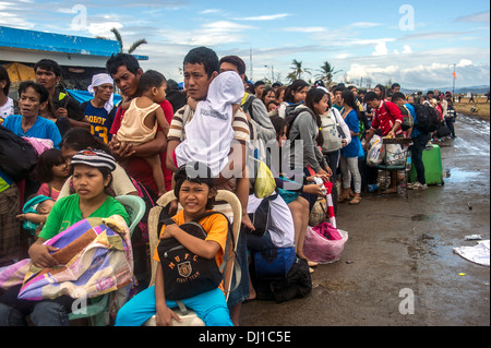 Anwohner warten, um Hilfsgüter in der Nachmahd des Super Taifun Haiyan 17. November 2013 in Tacloban, Philippinen erhalten. Stockfoto