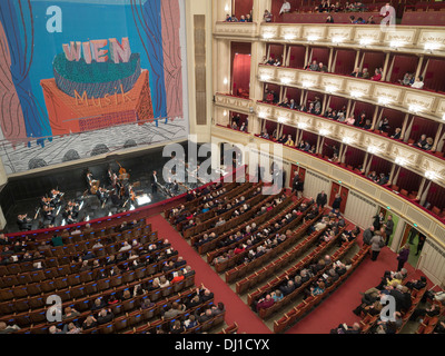 Bevor die Oper Gönner und das Orchester sitzen bekommen. Die Bühne ist mit einem Wandbild für Wien Musik als Menschen-Datei in gefüllt. Stockfoto