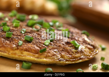 Frische hausgemachte spanische Tortilla (Omelette mit Kartoffeln) mit Frühlingszwiebeln an der Spitze Stockfoto