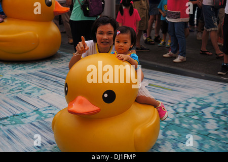 Frau und Kind posiert für ein Foto mit einer Ente, Hong Kong Stockfoto
