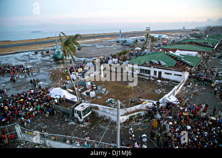 Bewohner zu sammeln, um die zerstörten Tacloban-Flugplatz für die Evakuierung nach Manila in der Nachmahd des Super Taifun Haiyan 14. November 2013 in Tacloban, Philippinen. Stockfoto