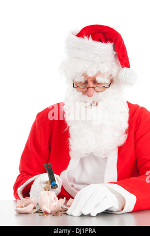 Santa bricht sein Sparschwein mit nur Münzen Stockfoto