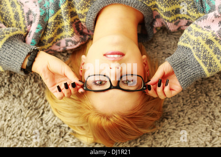 Porträt einer jungen Frau, die ihre Brille aufsetzen Stockfoto