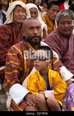 Bhutan, Thimpu Dzong, jährliche Tsechu, Vater und Sohn das Tragen von Sonnenbrillen im Publikum Stockfoto