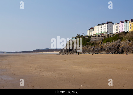 Eine Streuung von Menschen zu Fuß auf windigen Tenby South Beach im Frühling Sonnenschein, Pembrokeshire, Wales, UK Stockfoto