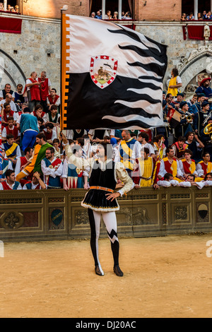 Mann hält eine Lupa Flagge, historischer Festzug vor das Pferderennen Palio di Siena, Siena, Toskana, Italien Stockfoto