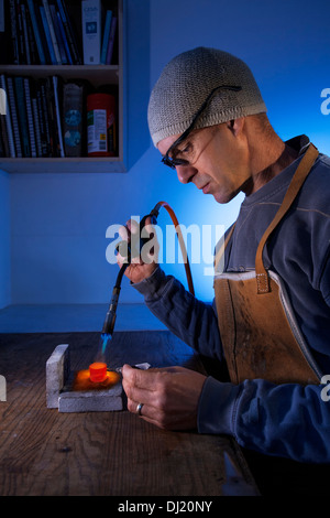 Mann mit einer Lötlampe auf eine Workshop-Bank. Stockfoto