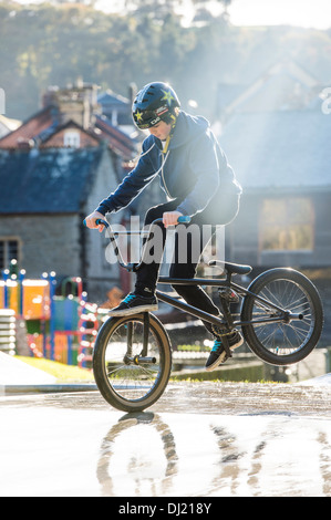 Ein Teenage Boy sein BMX Fahrrad tun Fuß Marmelade Endo Stunts auf einem Skateboard/BMX Park UK Stockfoto