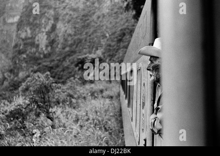 Ein mexikanischer Cowboy befasst sich mit der Dschungel im stehen zwischen den Wagen des legendären Chihuahua-Pacífico Zuges in Mexiko. Stockfoto