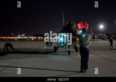 US Air Force Senior Airman Stephen Baran, Crewchief mit 169. Aircraft Maintenance Squadron auf gemeinsame National Guard Base McEntire in South Carolina Air National Guard, Marschälle ein Kampfpilot, seine f-16 Fighting Falcon Kampfjet auf die fl zu parken Stockfoto