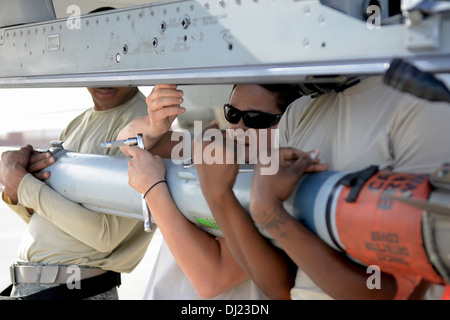 US Air Force Senior Airman Krystalane Laird, ein Waffen-Lader mit 169. Aircraft Maintenance Squadron auf gemeinsame National Guard Base McEntire in South Carolina Air National Guard, lädt eine Rakete auf den Flügel von einem Kampfjet f-16 Fighting Falcon an Stockfoto