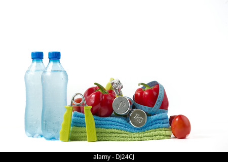 Fitness Hantel mit Gemüse und Wasser auf einem weißen Hintergrund. Stockfoto