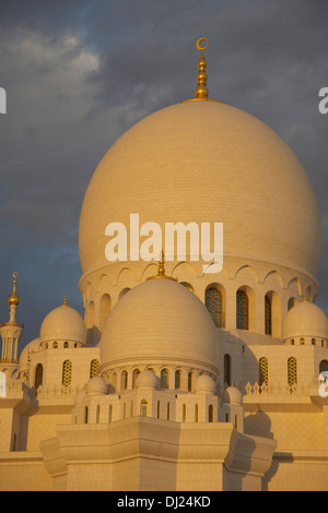 Sheikh Zayed Grand Mosque, Abu Dhabi, Vereinigte Arabische Emirate, bei Sonnenuntergang gegen ein bewölkter Himmel Stockfoto