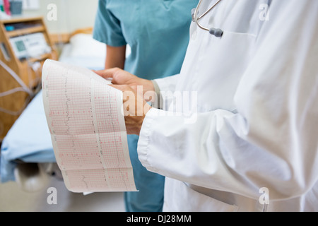 Mittelteil von Arzt und Krankenschwester mit fetalen Herzschlag Bericht Stockfoto