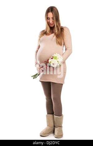 Schöne schwangere Frau mit Blumen auf weiß Stockfoto