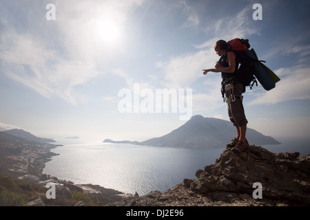 Junger Mann stehend auf einem Felsen gegen malerischen Blick auf Meer Stockfoto
