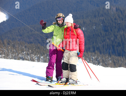 Junge weibliche Skifahrer und Snowboarder am Skilift Stockfoto