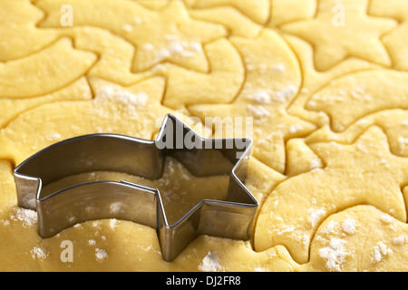 Ausschneiden von Weihnachtsgebäck aus Mürbeteig Teig mit einer Sternschnuppe geformte Cutter (Tiefenschärfe) Stockfoto