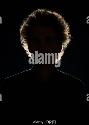 Vorderansicht der Mann im Schatten mit Hintergrundbeleuchtung auf schwarzem Hintergrund Stockfoto