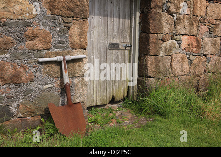 Torf-Schaufel außerhalb einer rosa Granit Schuppen auf der Isle of Iona in den Inneren Hebriden in Schottland Stockfoto