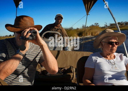 Ein paar Touristen genießen Sie eine Boot-Safari von Camp Eagle Island Camp von Orient-Express, außerhalb des Moremi Game Reserve Stockfoto