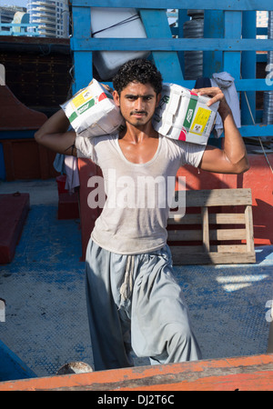 Mann laden Ladung auf Dhaus am Cargo Wharf auf The Creek in Dubai Vereinigte Arabische Emirate Stockfoto