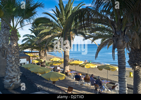 dh Strand PUERTO DEL CARMEN LANZAROTE Touristen sitzen Café Tische mit Blick auf alfresco Cafés Strandurlaub Stockfoto