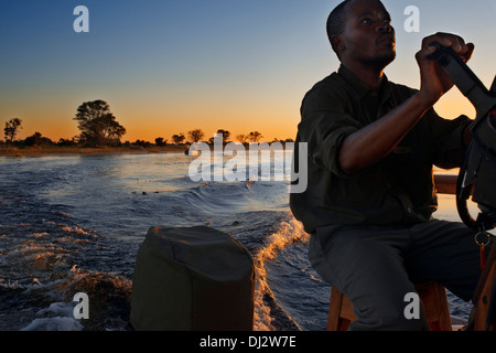 Segeln bei Sonnenuntergang auf einem Schnellboot im Wasser Safari Camp in Eagle Island Camp von Orient-Express, außerhalb des Moremi-Spiels. Stockfoto