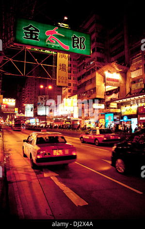 Zeichen, Menschen und Taxis in der Nacht an der Nathan Road in Kowloon, Hongkong Stockfoto