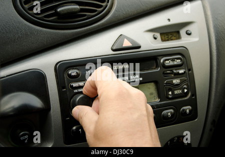 Nahaufnahme von Personen Hand drehen Sie die Lautstärke des Autoradios während der Fahrt. Stockfoto