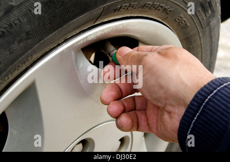 Nahaufnahme von Personen Hand, Ausbau der Gap ein Autoreifen für den Druck zu prüfen. Stockfoto