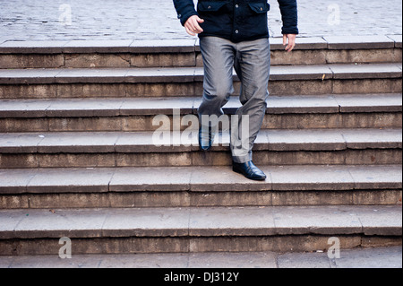 Ein Geschäftsmann steigt Treppen, die im urbanen Umfeld Stockfoto