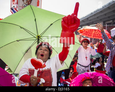 Bangkok, Thailand. 20. November 2013. Ein rotes Hemd Unterstützer Wellen einen große rote Finger, während sie zur Unterstützung der Regierung Kundgebungen. Tausende von Red Shirts liefern Unterstützer der Pheu Thai Partei in Thailand, versammelten sich im Rajamangala-Stadion in vorstädtischen Bangkok zu hören das thailändische Verfassungsgericht Urteil sein Urteil gegen die Regierung. Das Gericht entschied, dass die jüngsten Bemühungen der Regierung, eine Decke Amnestie Gesetz der thailändischen Verfassung verletzt aber das Gericht nicht die Partei aufzulösen oder die Auflösung der Regierung, die am meisten gefürchtet hatte. (Bild Kredit: Stockfoto