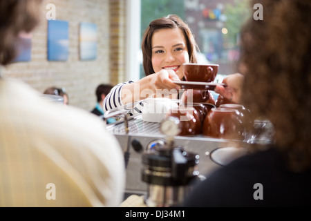 Kunden nehmen Kaffee von Barista Stockfoto