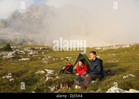 Junge Menschen Campingplatz in den Bergen im Nebel und den Sonnenuntergang genießen Stockfoto