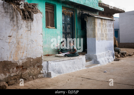 Junge indische Mädchen tun Schule arbeiten außerhalb ihrer indischen Dorf nach Hause. Andhra Pradesh, Indien Stockfoto