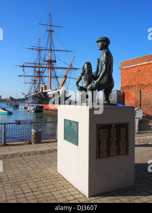 Die Mudlarks-Statue mit HMS Krieger im Hintergrund auf der Festplatte, Portsmouth, England Stockfoto