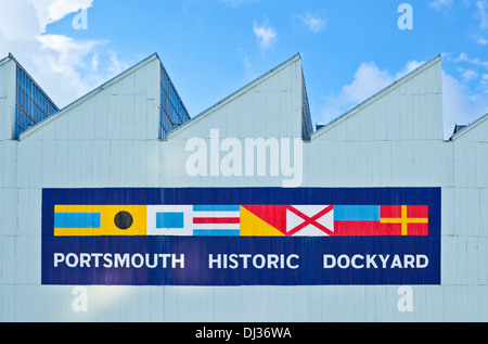 Portsmouth historic Dockyard Schild mit Fahnen an der Seite eines Gebäudes in der Schiffswerft Portsmouth Hampshire England UK GB EU Stockfoto