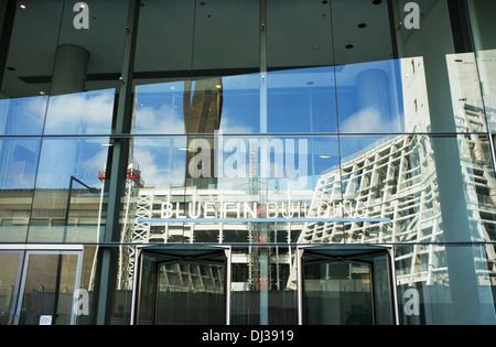 Die Erweiterung zur Tate Modern im Bau, spiegelt sich in den Eingang zum Blue-Fin-Gebäude, Bankside, Southwark, London. Stockfoto