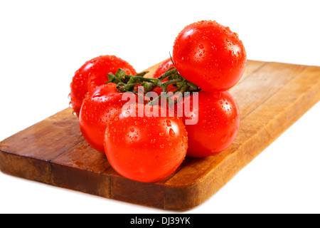 Zweig der Tomaten mit Wasser fällt auf weißem Hintergrund Stockfoto