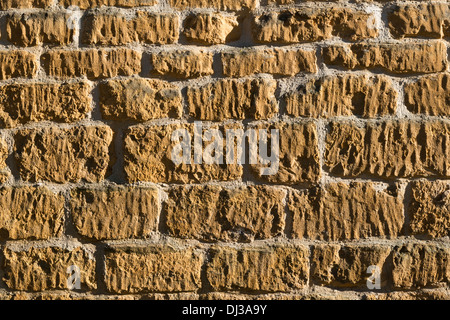 Nahaufnahme einer Cotswold Kalkstein Steinmauer im Streiflicht zeigen die Textur Stockfoto
