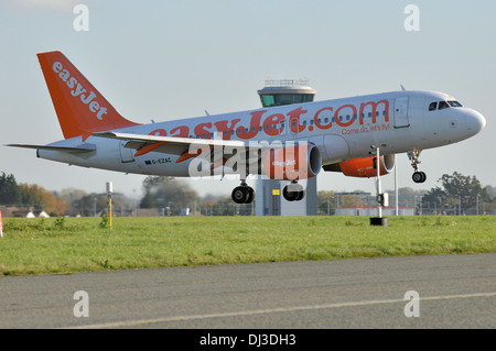 EasyJet Airbus A319 G-EZAC zu landen am Flughafen London Southend, Essex, UK mit dem neuen Kontrollturm hinter Stockfoto