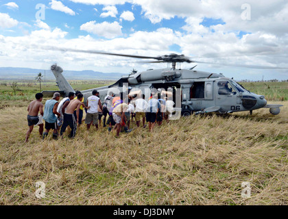 Ein US-Marine MH-60 s Sea Hawk-Hubschrauber liefert humanitäre Hilfsgüter für die Opfer der Taifun Haiyan 16. November 2013 in Mahayag, Philippinen. Stockfoto