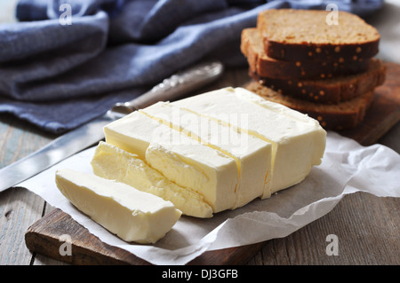 In Scheiben geschnittene Butter auf hölzernen Cutting Board closeup Stockfoto