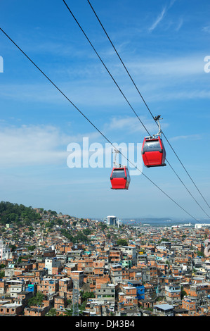Rote Kabel Autos fahren im blauen Himmel über Rio De Janeiro Favela Complexo Alemao Stockfoto