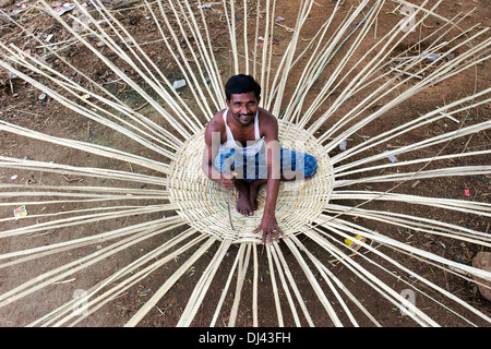 Indischer Mann Weben eine traditionelle Ziegengehege aus Bambus in einem indischen Dorf. Andhra Pradesh, Indien Stockfoto